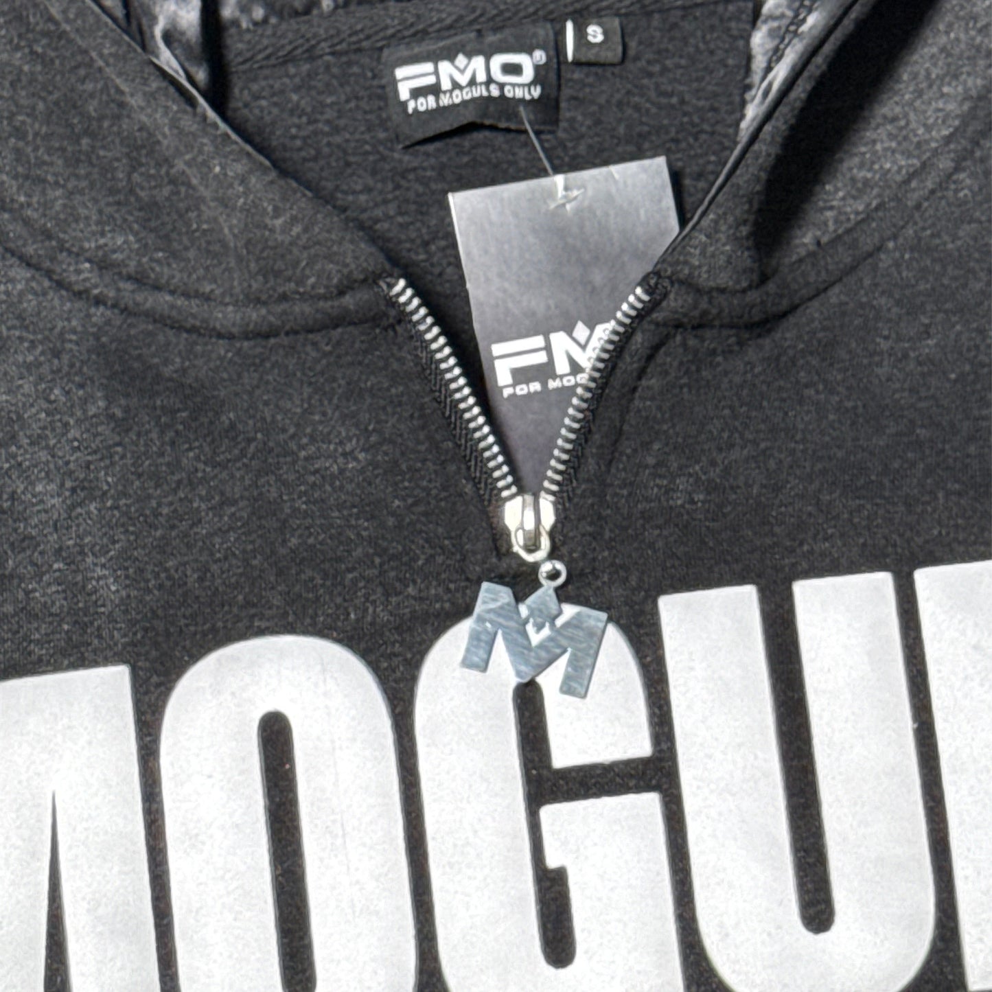 Close-up of 4 Moguls Oversized Sweatsuit hoodie showing zipper detail, chest logo, and mineral wash texture