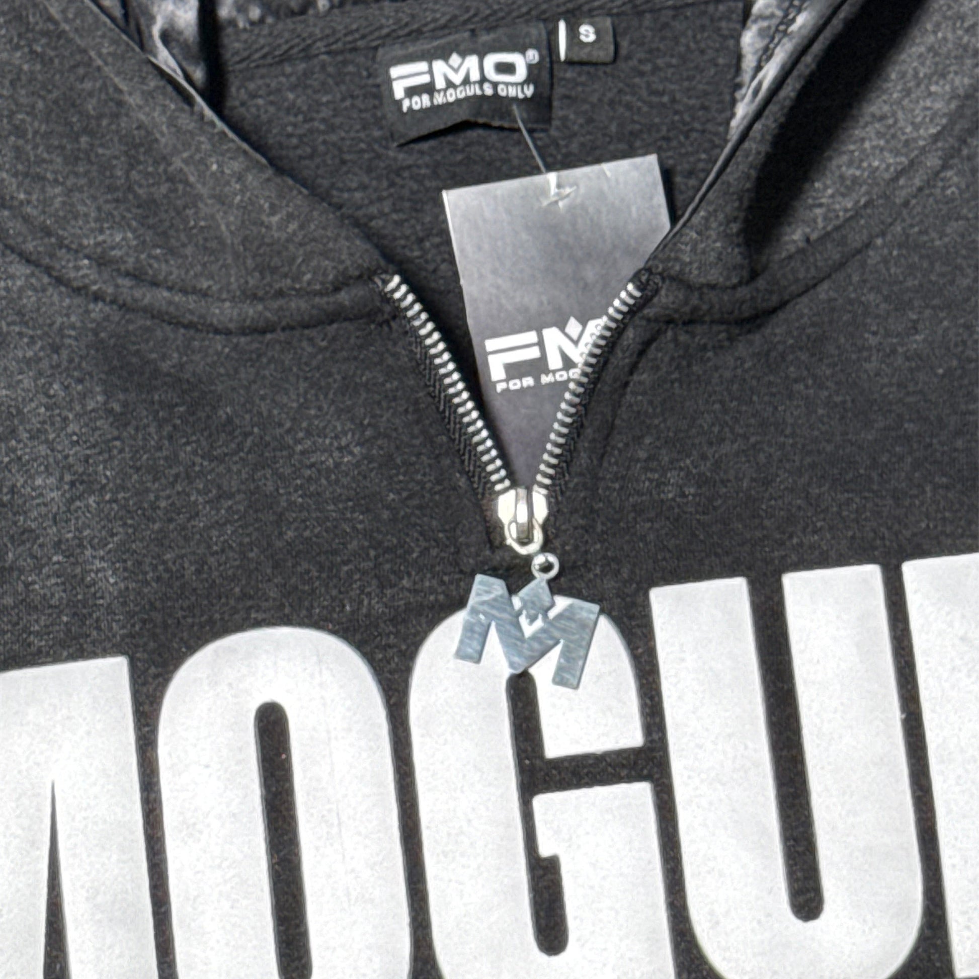 Close-up of 4 Moguls Oversized Sweatsuit hoodie showing zipper detail, chest logo, and mineral wash texture