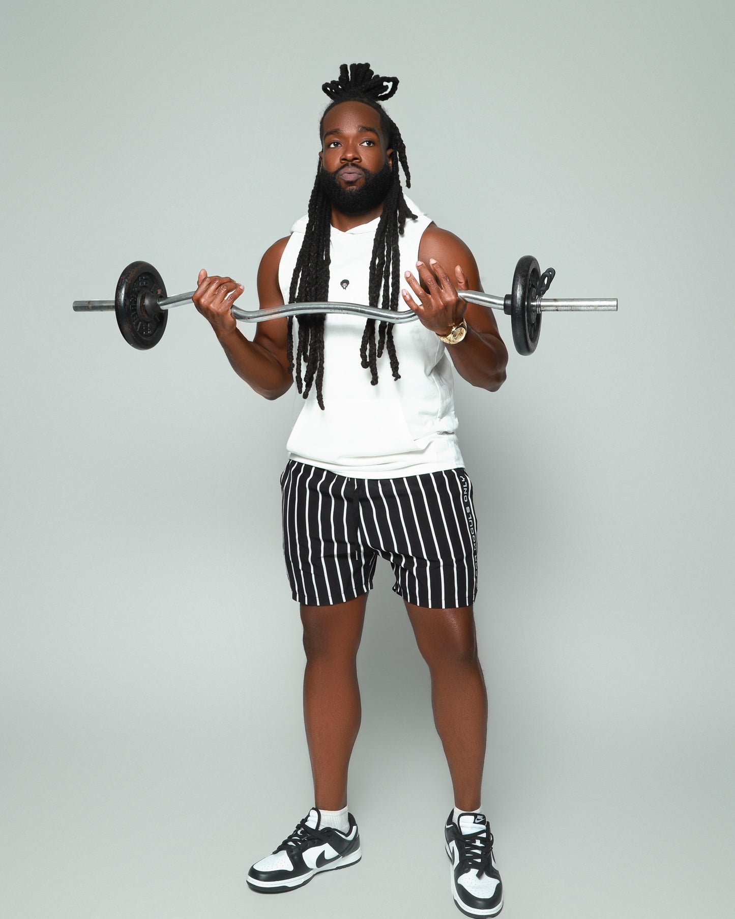 Elevated Coaching by For Moguls Only featuring fitness coach performing barbell curls. Personalized training, nutrition guidance, accountability coaching, and sustainable fitness transformation.