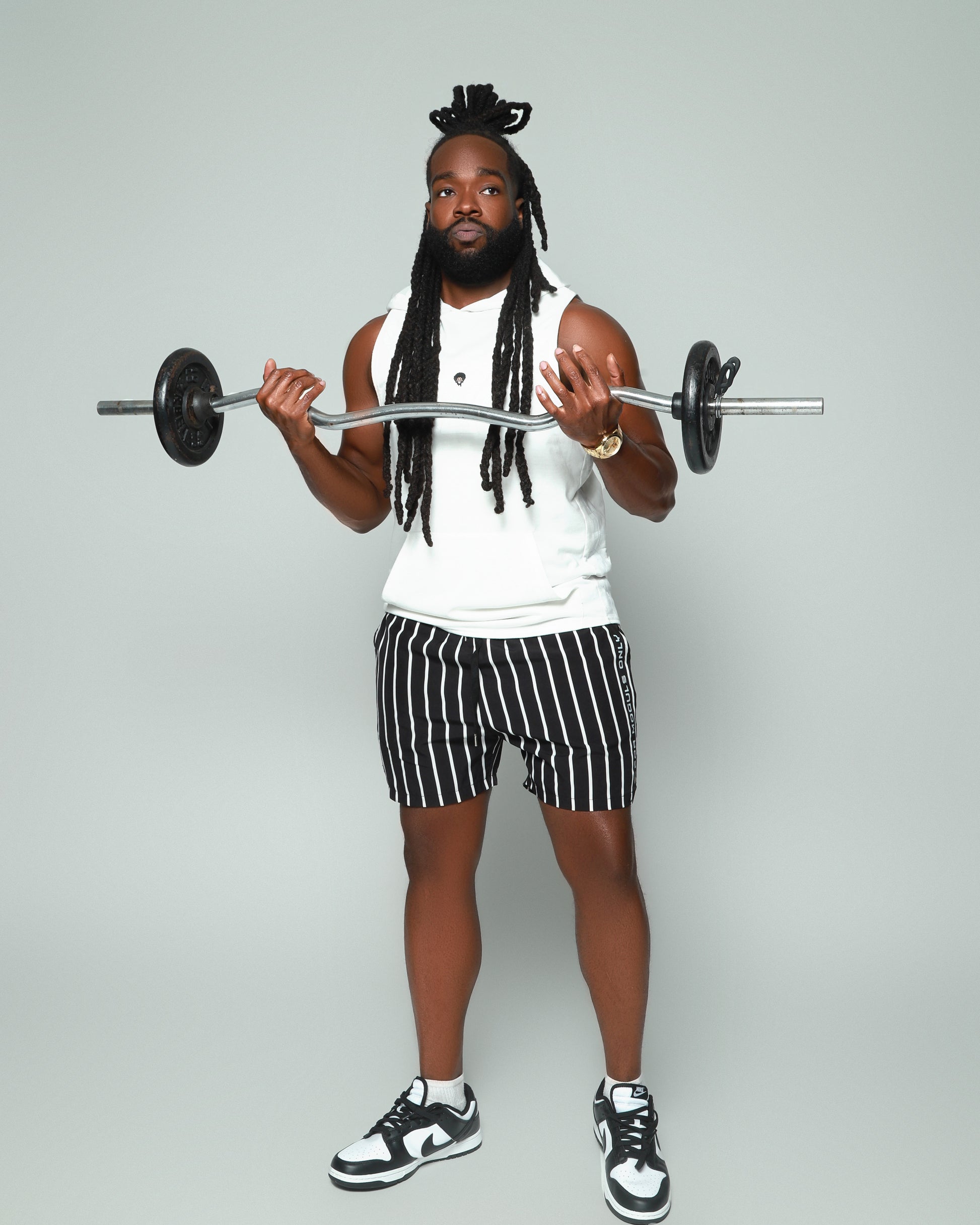 Elevated Coaching by For Moguls Only featuring fitness coach performing barbell curls. Personalized training, nutrition guidance, accountability coaching, and sustainable fitness transformation.