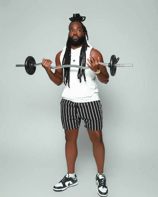 Elevated Coaching by For Moguls Only featuring fitness coach performing barbell curls. Personalized training, nutrition guidance, accountability coaching, and sustainable fitness transformation.