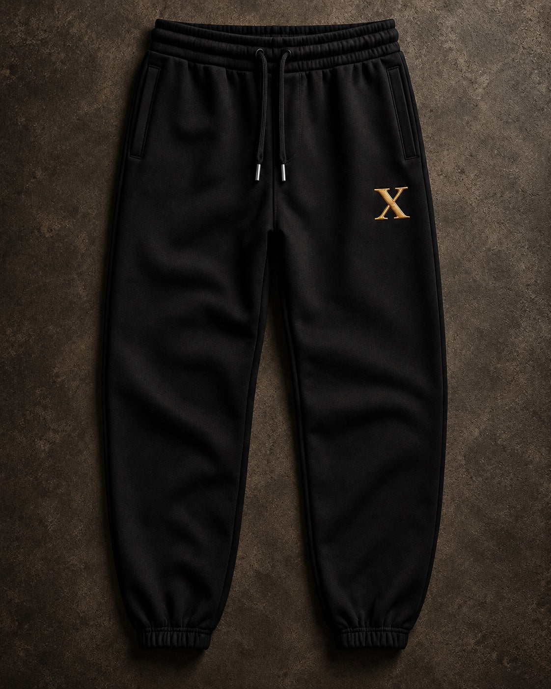FMO X Anniversary Jogger front view in black with gold Anniversary X and metal-tipped drawcords.