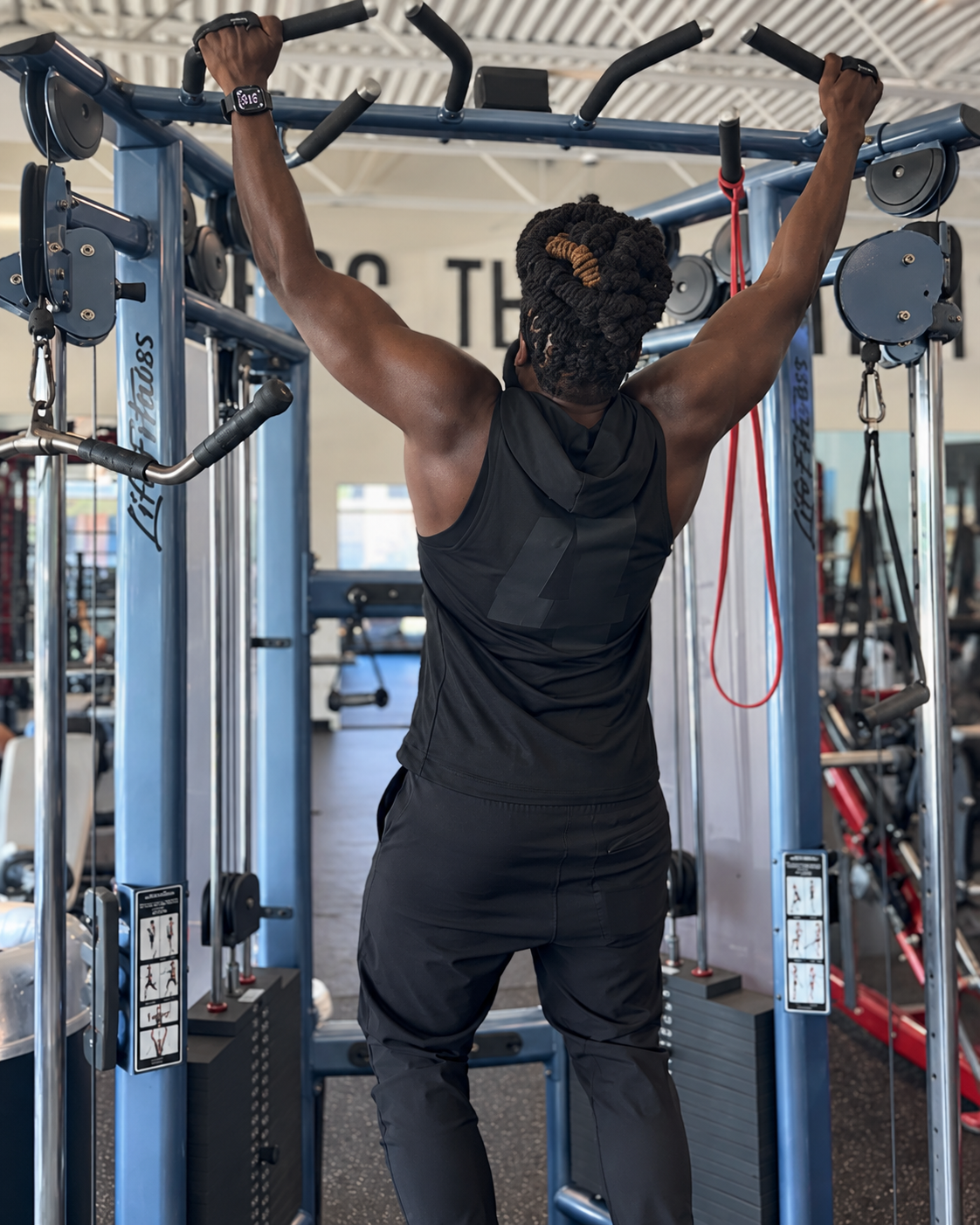 Rear view of a model training in the black Quiet Hood sleeveless performance hoodie